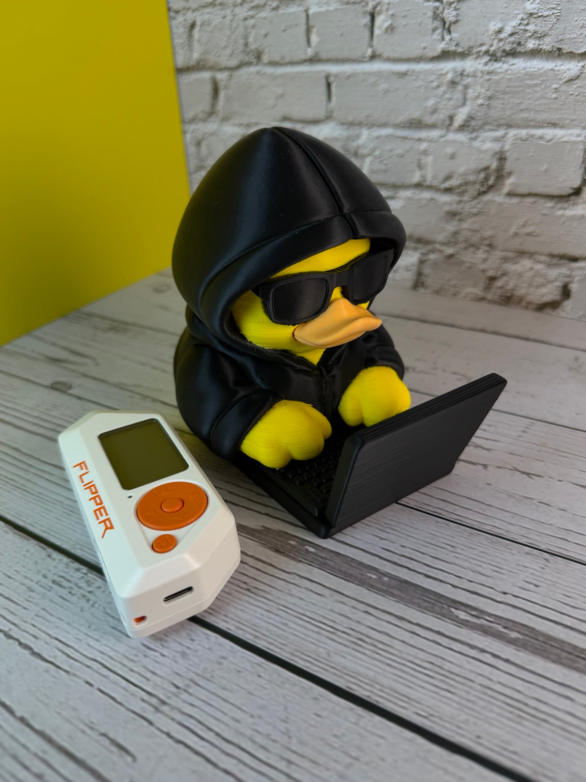 Rubber Hacky Black Hat Operative collectible detail view with Flipper Zero for scale