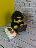 Rubber Hacky Black Hat Operative collectible with Flipper Zero for scale